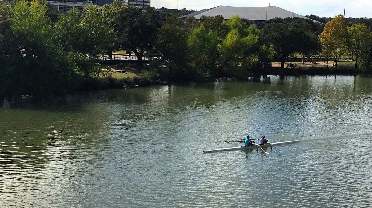 Two rowers in a double scull on Lady Bird Lake in Austin