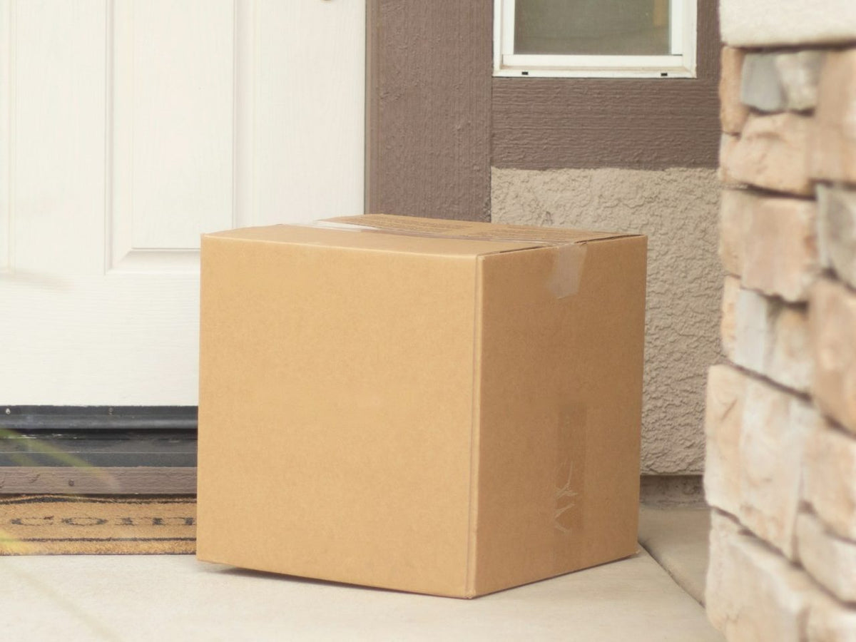 A plain cardboard box at a front door